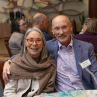 Michael McDonnell and woman sitting at table, smiling for camera